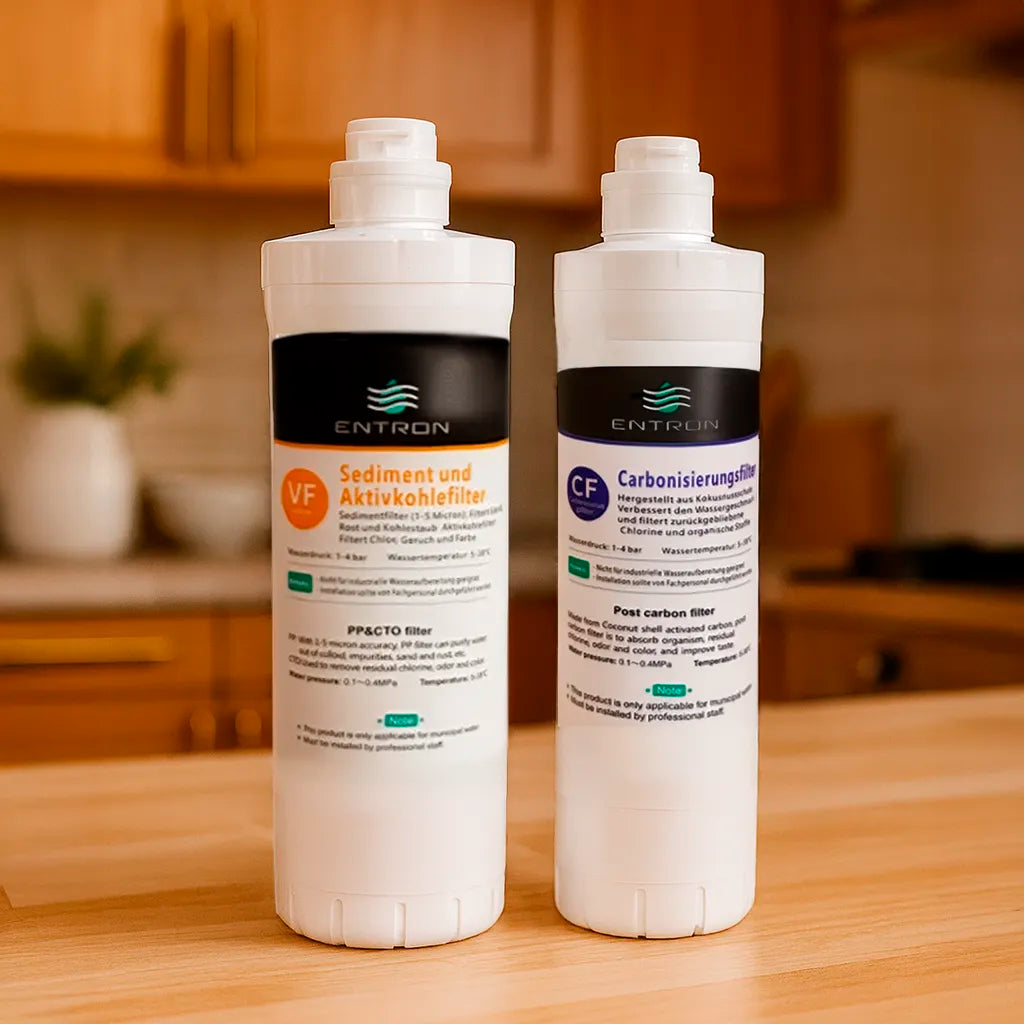 Das Osmose Ersatzfilter-Set bestehend aus: Sediment- und Aktivkohlefilter und Carbonisierungsfilter für die Entron F-Serie - stehend in einer warmen Küche
